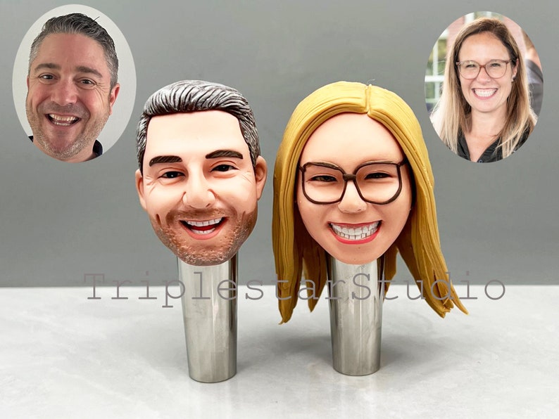 May include: Two personalized bottle stoppers with realistic faces. The stoppers are made of a brown, clay-like material and are mounted on silver metal bases. The stoppers are a fun and unique way to add a personal touch to your home bar.