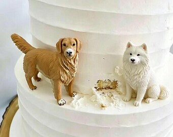 May include: A white tiered cake featuring two dog figurines on the surface. One figurine is a golden-brown dog standing with its tail raised, and the other is a white, fluffy dog sitting upright. Both figures are placed on the white frosting.