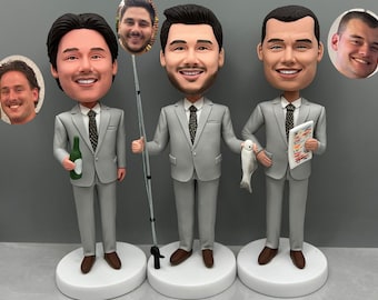May include: Three custom-made figurines of men in gray suits. Each figurine has a different head and is holding a different prop. One figurine is holding a bottle of beer, another is holding a fishing rod, and the third is holding a fish and a menu.