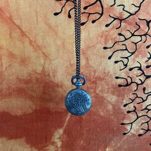 Vintage foral filigree flip open pendant with various gems inside