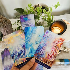 May include: A set of five tarot cards with colorful, abstract designs. The cards feature images of butterflies, a couple embracing, and a glowing orb. The card titles are "Self Love & Inner Unity", "Hieros Gamos", and "Recognitia".