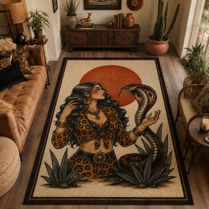 Op de afbeelding: Een rechthoekig vloerkleed met een centrale illustratie van een persoon met lang donker haar in een top en rok met luipaardprint, versierd met gouden sieraden. Een grote cobra kronkelt ernaast, tegen de achtergrond van een grote oranje zon.