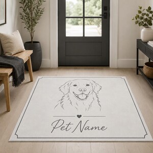 May include: A rectangular area rug featuring a white surface with a thin black border. The center displays a black line-art illustration of a dog's head above a small heart icon and the customizable text Pet Name in a cursive script font.