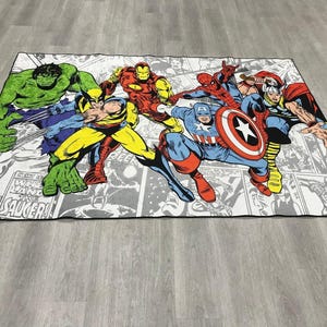 May include: A rectangular area rug featuring a colorful comic book print of Marvel superheroes including Hulk, Wolverine, Iron Man, Spider-Man, Captain America, and Thor. The background consists of black and white comic panels with text.