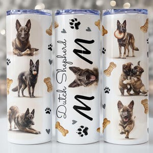 May include: A white tumbler featuring various images of Dutch Shepherd dogs, paw prints, and bone-shaped treats. The words "Dutch Shepherd" and the letter "M" are also displayed. The tumbler has a silver lid and is designed for beverages.