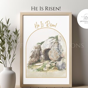 May include: A watercolor painting of a stone tomb with a large, round stone rolled away. The tomb is surrounded by greenery and the words "He Is Risen!" are written in gold lettering above the tomb.