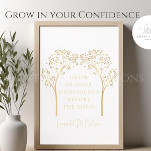 May include: Gold foil print with a quote about growing in confidence before the Lord, by Russell M. Nelson. The quote is surrounded by two stylized trees with gold leaves.
