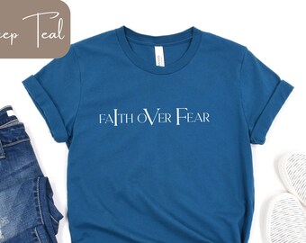 May include: A deep teal t-shirt with the text "FAITH OVER FEAR" in white lettering.