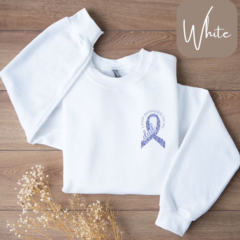 May include: White sweatshirt with a purple ribbon design that says "I wear periwinkle for my dad".