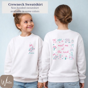 May include: White crewneck sweatshirt with ice skate graphic and the name "Jamie" in teal. The back features a "meet me at the rink" design with ice skates, bows, and other illustrations. The sweatshirt is non-hooded.