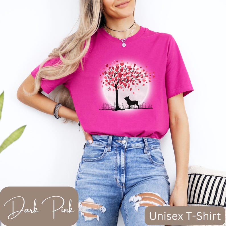 May include: A pink unisex t-shirt with a graphic of a silhouette of a dog standing in front of a tree with pink hearts for leaves. The tree is in front of a full moon.