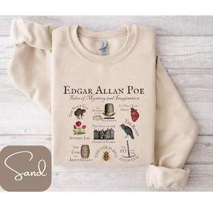 Könnte beinhalten: Ein beiger Pullover mit einem grafischen Druck der berühmten Geschichten von Edgar Allan Poe. Der Druck zeigt Illustrationen zu jeder Geschichte, darunter "Die schwarze Katze", "Die Morde in der Rue Morgue", "Annabel Lee", "Der Fall des Hauses Usher", "Das verräterische Herz", "Der Rabe", "Der Fass Amontillado", "Der Goldkäfer" und "Die Grube und das Pendel".