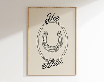 May include: A black and white illustration of a horseshoe in a circle with the words "Yee Haw" written in a cursive font.
