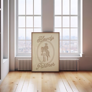 May include: A framed print with a beige background featuring a line drawing of a cowboy riding a horse. The text "Howdy Partner" is written in a stylized font.