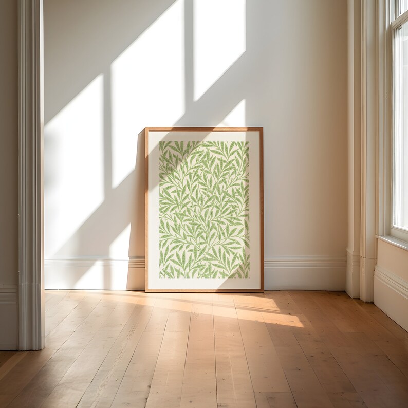 May include: A framed print of a green and white floral pattern. The print is in a wooden frame and is hanging on a white wall.