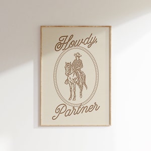 May include: A framed print with a cowboy riding a horse in a circle with the text "Howdy, Partner" in a cursive font.