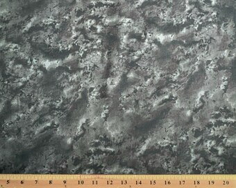 May include: A piece of fabric with a mottled pattern in shades of gray and white. A wooden ruler with inch markings is placed across the bottom of the fabric, measuring from 5 to 20 inches.