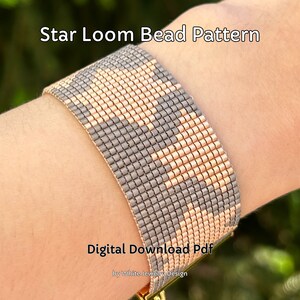 Puede incluir: Un brazalete de cuentas de telar gris y melocotón con un patrón de estrella. El brazalete está en la muñeca de una persona. El texto "Star Loom Bead Pattern" y "Digital Download Pdf" es visible en la imagen. El texto "by White Jewelry Design" también es visible.