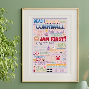 Può includere: Un'opera d'arte a punto croce incorniciata con la parola "Cornwall" e altre parole e frasi associate alla Cornovaglia, in Inghilterra. L'opera è in una cornice di legno.