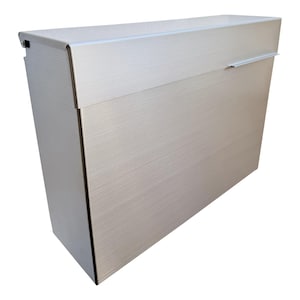 May include: A brushed metal mailbox with a rectangular shape. The mailbox has a horizontal slot for mail and a small handle. The surface has a textured, linear pattern. The color is a light silver.
