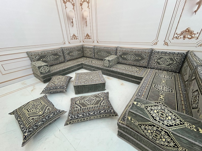 May include: A gray and black patterned L-shaped sectional sofa with multiple cushions. The sofa is made of fabric and has a traditional design.