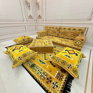 May include: A yellow and black patterned rug with fringe, a yellow sofa with matching cushions, and a yellow and black patterned footstool.