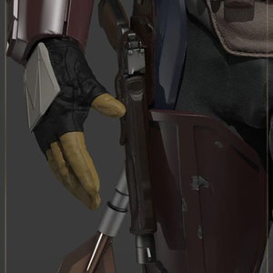 May include: A close-up of a brown leather belt with a silver buckle. The belt is worn over a dark blue fabric and a brown leather holster. A silver gun is in the holster. The text "THE MANDALORIAN" is visible in the top left corner of the image.