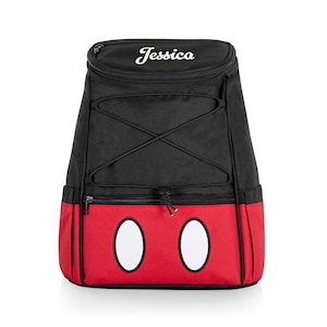 May include: Black and red insulated backpack with a Mickey Mouse design. The backpack has a drawstring closure and a zippered pocket on the front. The name "Jessica" is embroidered on the top of the backpack.