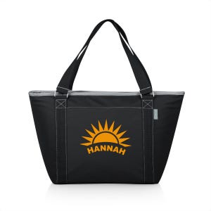 Puede incluir: Bolsa de transporte aislada negra con cierre de cremallera y dos asas superiores. La bolsa presenta un gr&aacute;fico de sol amarillo con el nombre "HANNAH" impreso debajo.