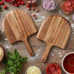 May include: Two wooden pizza peels with a handle and a rounded top. Each peel has a circular logo with the letter "S" and the text "EST 2021 SANDERS". The peels are surrounded by pizza ingredients like tomatoes, onions, and pepperoni.
