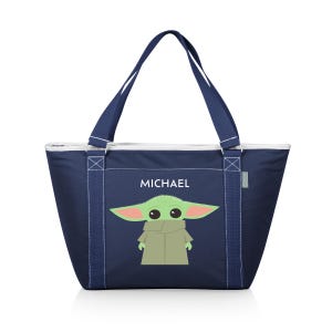 Puede incluir: Una bolsa de lona azul marino con una cremallera blanca y asas blancas. La bolsa tiene un personaje verde con ojos grandes y un abrigo marr&oacute;n. El nombre "MICHAEL" est&aacute; impreso en blanco en la bolsa.