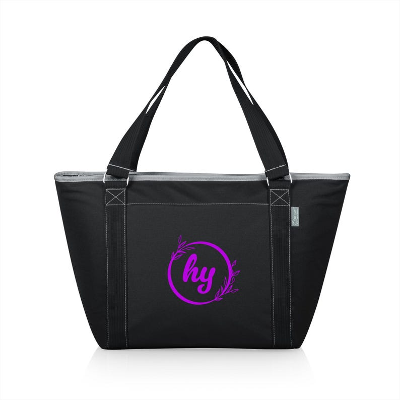 Puede incluir: Bolso tote negro con cremallera, con una cremallera blanca y asas. El bolso tiene un c&iacute;rculo morado con las letras "hy" y dise&ntilde;os florales.