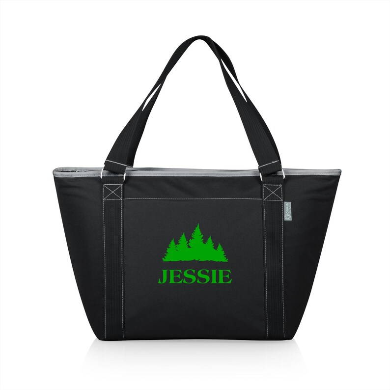 Puede incluir: Bolsa de transporte aislada negra con cierre de cremallera y dos asas superiores. La bolsa tiene un dise&ntilde;o bordado verde de un grupo de &aacute;rboles con el nombre "JESSIE" debajo.