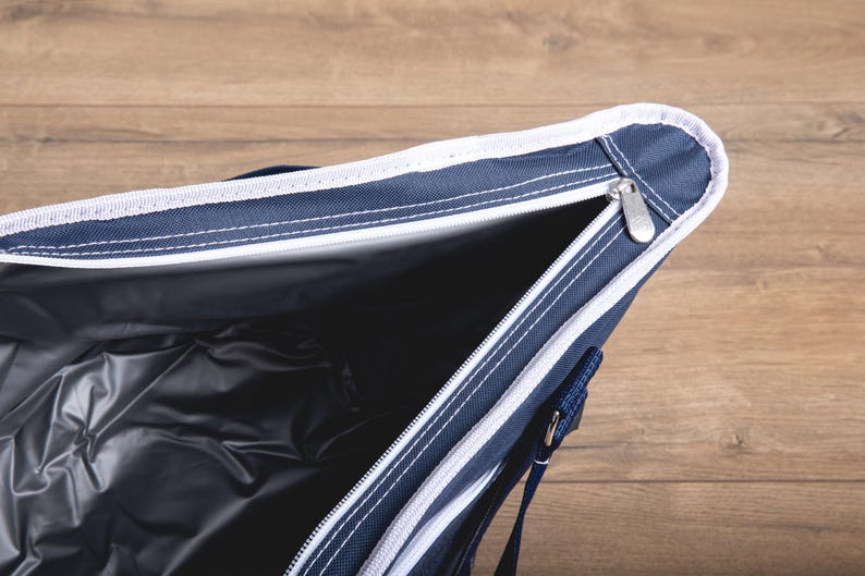 Puede incluir: Una bolsa de refrigeraci&oacute;n azul y blanca con cierre de cremallera. La bolsa est&aacute; abierta y el interior est&aacute; forrado con un material plateado.