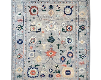 May include: A gray rug with a traditional Persian design. The rug features intricate patterns in shades of blue, red, and green.