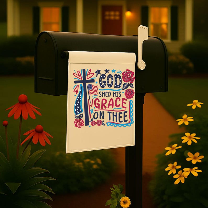 Pu&ograve; includere: Un cartello bianco con una croce rosso, bianco e blu e il testo "God Shed His Grace On Thee" in un design patriottico colorato. Il cartello &egrave; attaccato a una cassetta delle lettere nera.