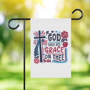 Pu&ograve; includere: Una bandiera da giardino bianca con un design patriottico rosso, bianco e blu. La bandiera presenta una croce, stelle, cuori e il testo "God Shed His Grace On Thee".