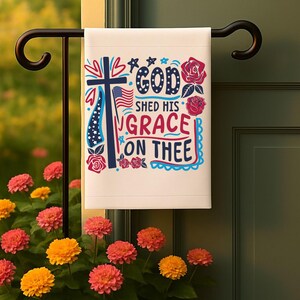 Pu&ograve; includere: Una bandiera da giardino bianca con un design patriottico rosso, bianco e blu. La bandiera presenta una croce, stelle, cuori e rose. Il testo sulla bandiera recita "God Shed His Grace On Thee".