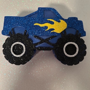 Pu&ograve; includere: Camion monster blu con fiamme gialle, pneumatici neri con cerchi bianchi e finitura glitter.