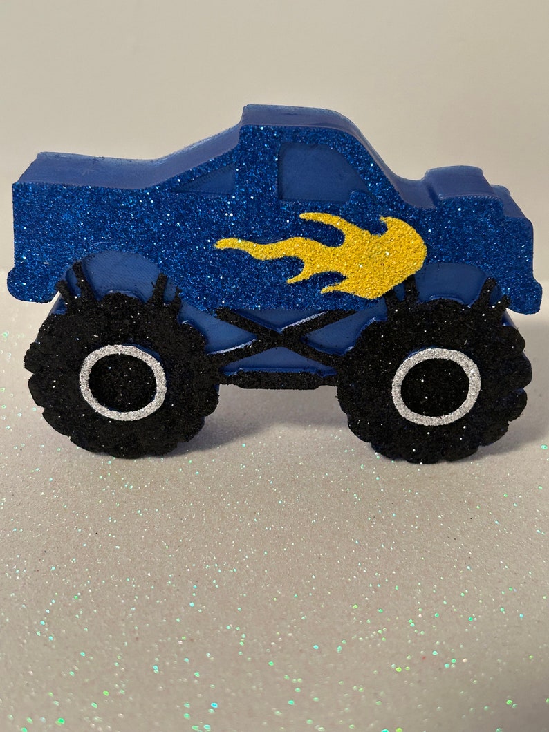 Pu&ograve; includere: Camion monster blu con pneumatici neri e un design a fiamma gialla. Il camion &egrave; fatto di schiuma e ricoperto di glitter.