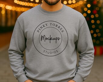 May include: A grey crew neck sweatshirt featuring the text "PINKY TORRES Mockups STUDIOS" in a black circular design. The sweatshirt is a solid colour and has long sleeves. The person is wearing the sweatshirt.