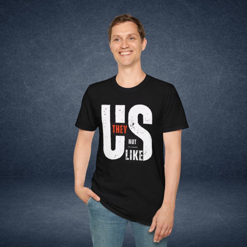 Puede incluir: Camiseta negra con un gr&aacute;fico blanco que dice "US" con las palabras "They Not Like" dentro de las letras.