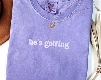 He's Golfing Comfort Colors® Shirt, Golf Mom Shirt, Golfer Wife Tee, Golf Season Gift Idea, Funny Golf Player Tshirt