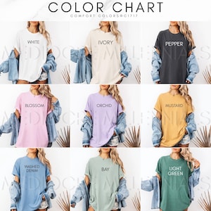 Puede incluir: Carta de colores con camisetas en varios colores, incluyendo blanco, marfil, pimienta, flor, orqu&iacute;dea, mostaza, denim lavado, bah&iacute;a y verde claro. Cada camiseta tiene el nombre del color impreso. El texto "COLOR CHART" y "COMFORT COLORS C1717" est&aacute;n en la parte superior.