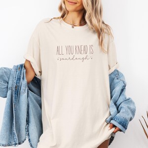 May include: A white t-shirt with the text "All you knead is *sourdough*" printed on it.