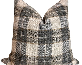 May include: A brown, black, and beige plaid throw pillow with a square pattern.