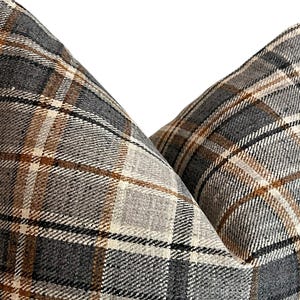 May include: Two pillow covers with a brown, beige, and gray plaid pattern.