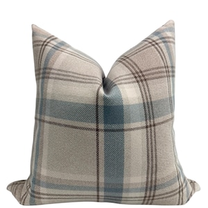 May include: A decorative throw pillow with a plaid pattern in shades of brown, blue, and white.