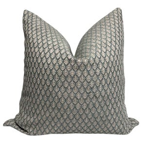 May include: A decorative throw pillow with a geometric pattern in shades of green and white.