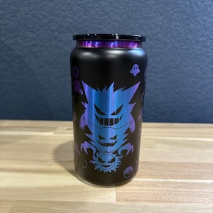 以下が含まれることがあります： 黒いステンレス製のウォーターボトルで、紫色の虹色のデザインが施されています。ボトルには黒い蓋が付いており、他のポケモンの幽霊で飾られています。